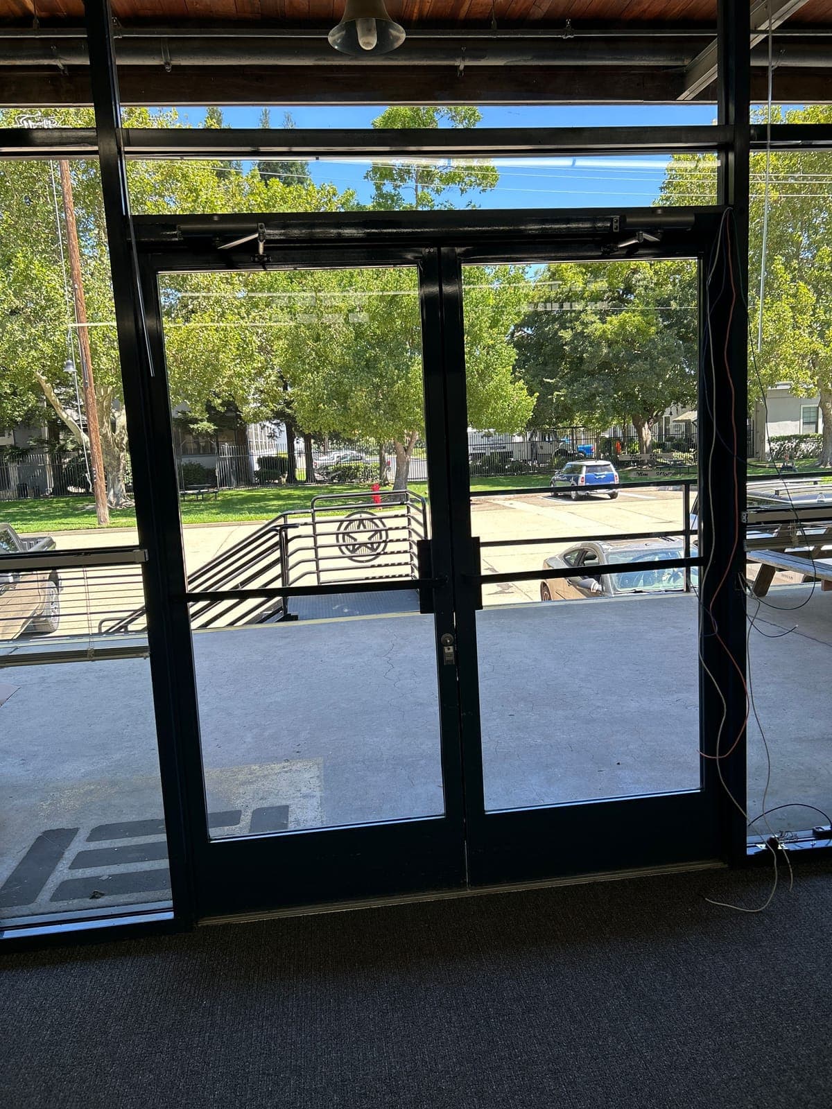Double glass entry with low-voltage wires run down the side of the aluminum frame during installation.
