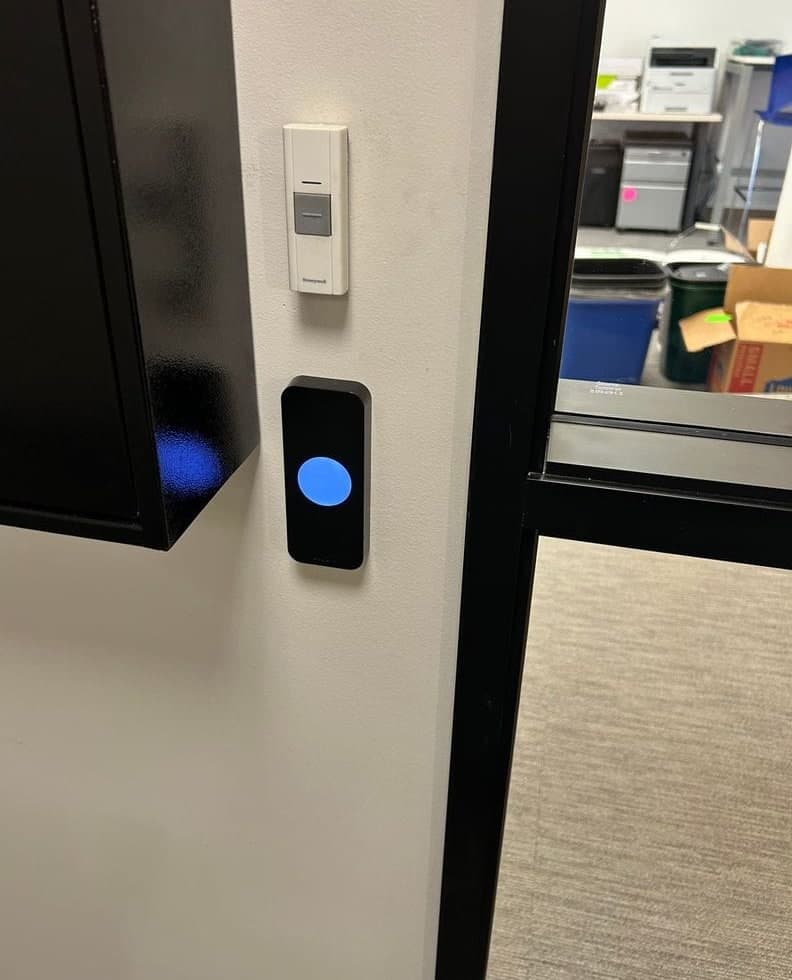 Before and after: an office suite entry with an existing reader beside the glass sidelite, then a Kisi reader in the same spot.