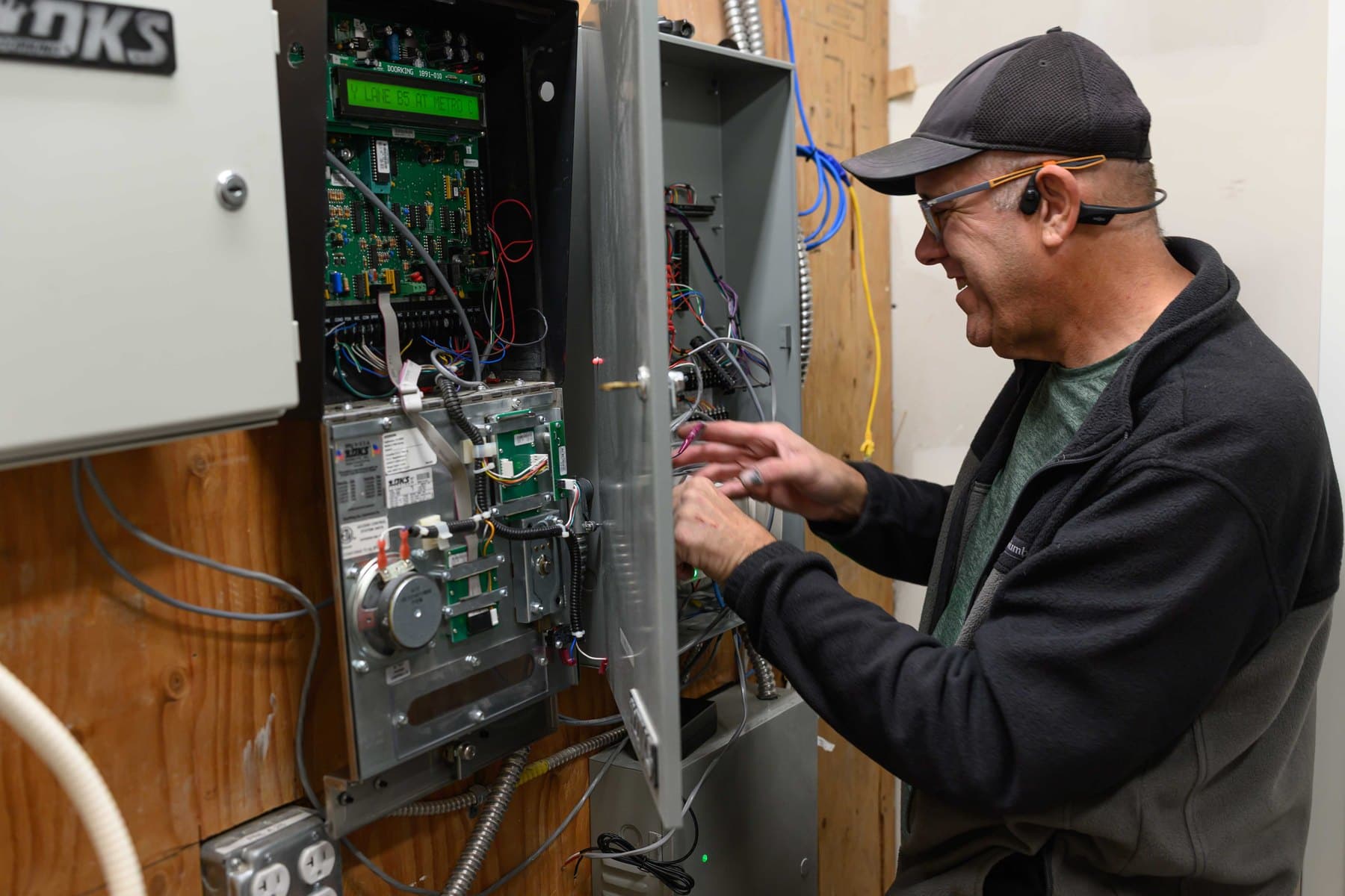 Elwin Security technician diagnosing wiring and components inside a commercial access-control panel.