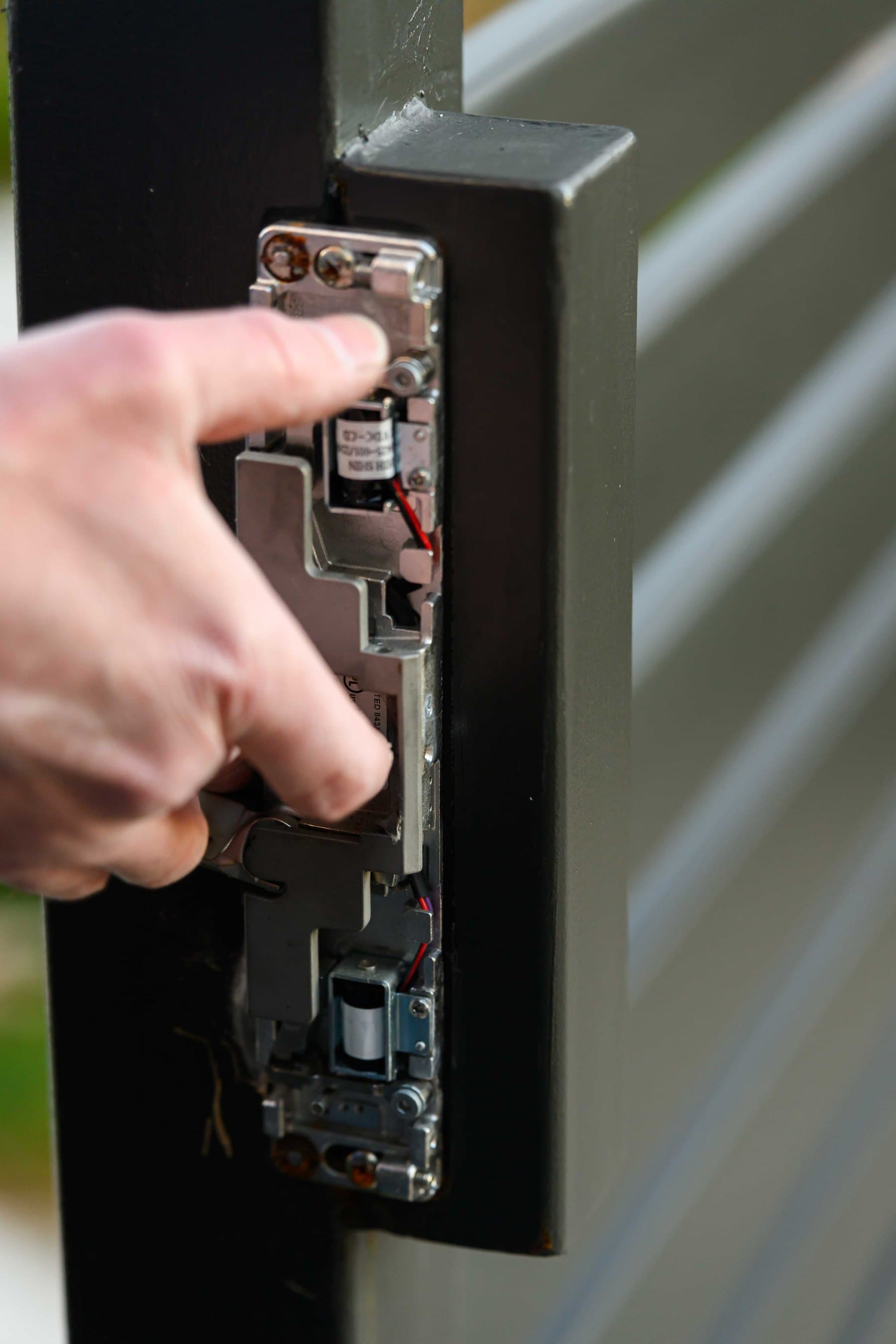 Close field view of electric strike and gate hardware at a Bay Area property.