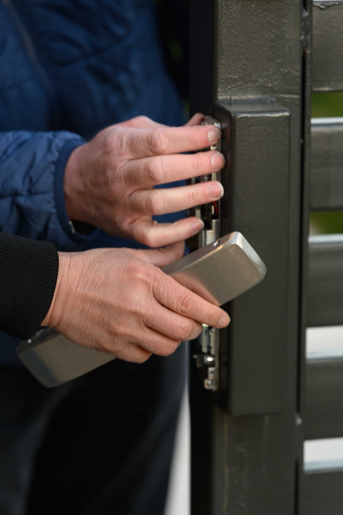 Elwin technician fitting a stainless cover over an exposed electrified lock at a Bay Area opening.