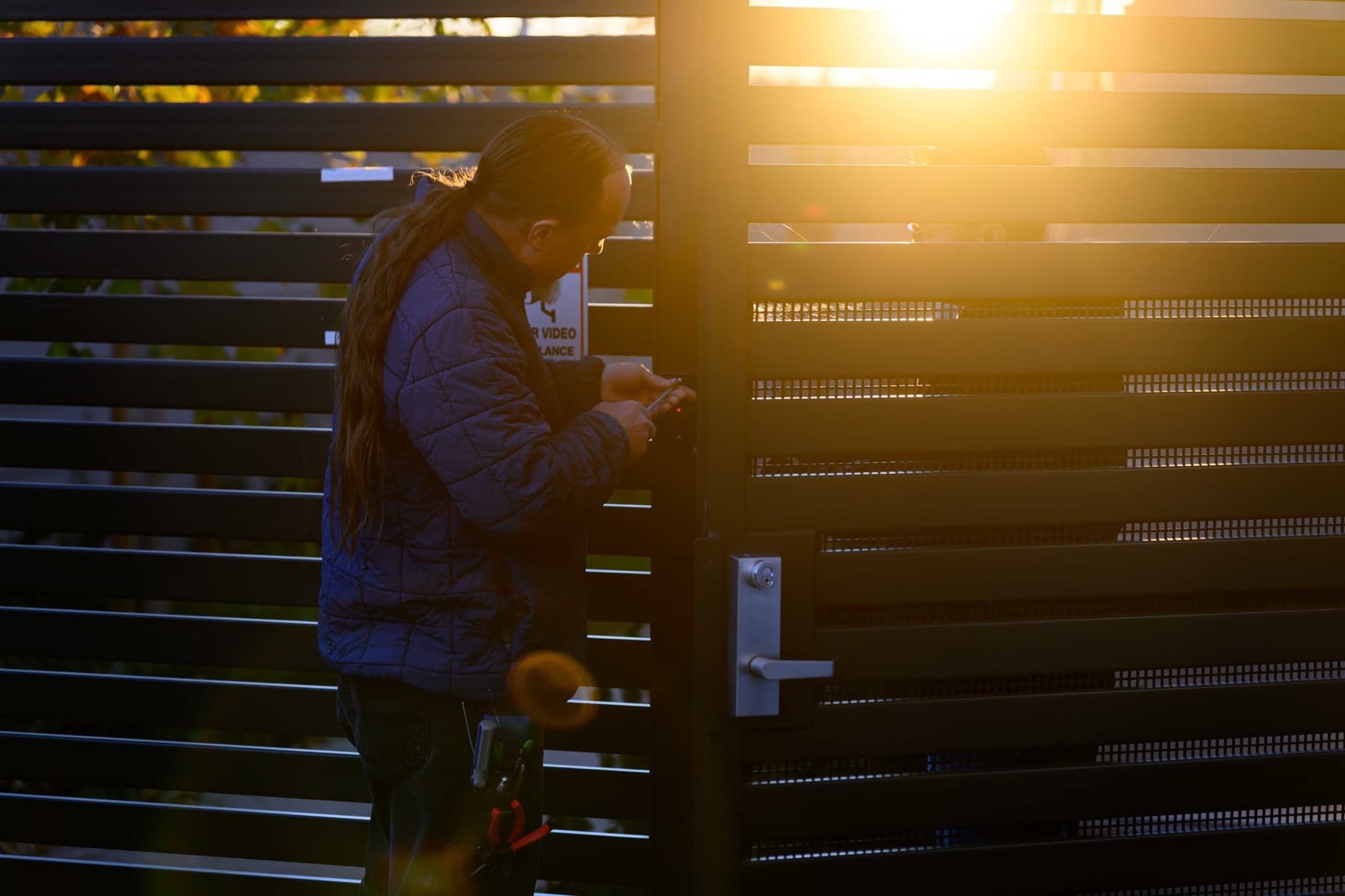 Elwin technician servicing a lock with lever handle and key cylinder at a Bay Area gate.