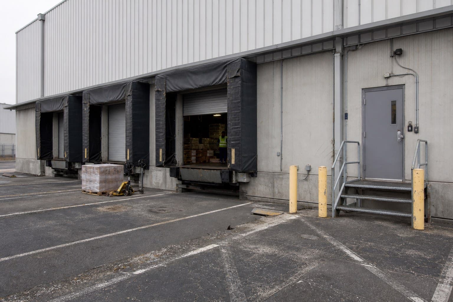 Representative industrial facility entrance with a pedestrian door, roll-up door, and access control