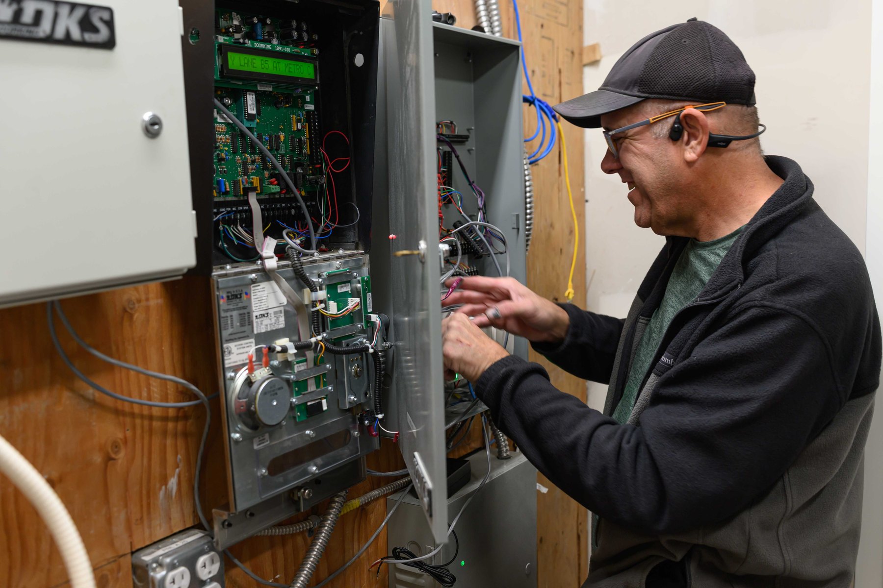 Technician working inside an access control panel.
