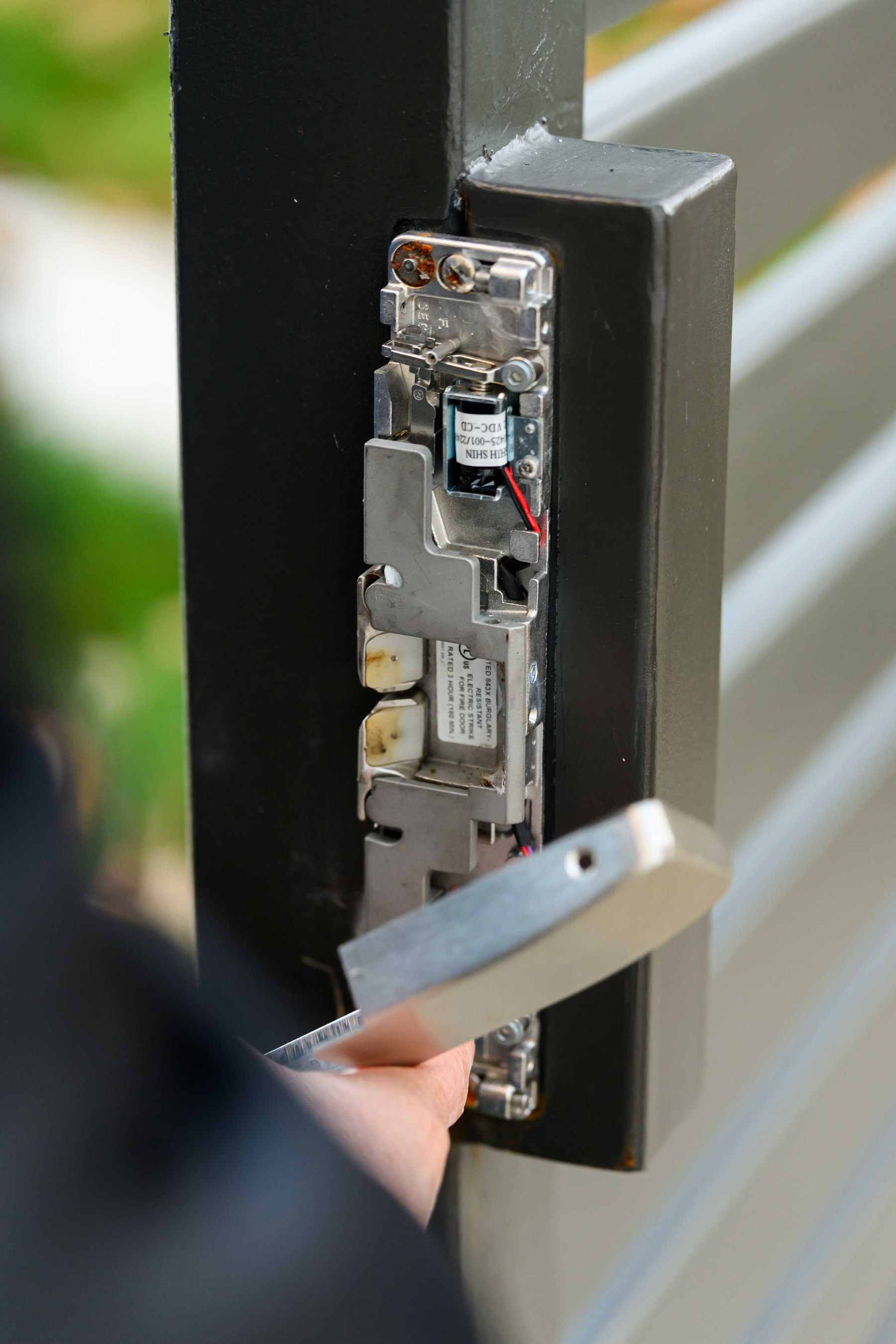 Close view of a gate strike and latch hardware assembly.