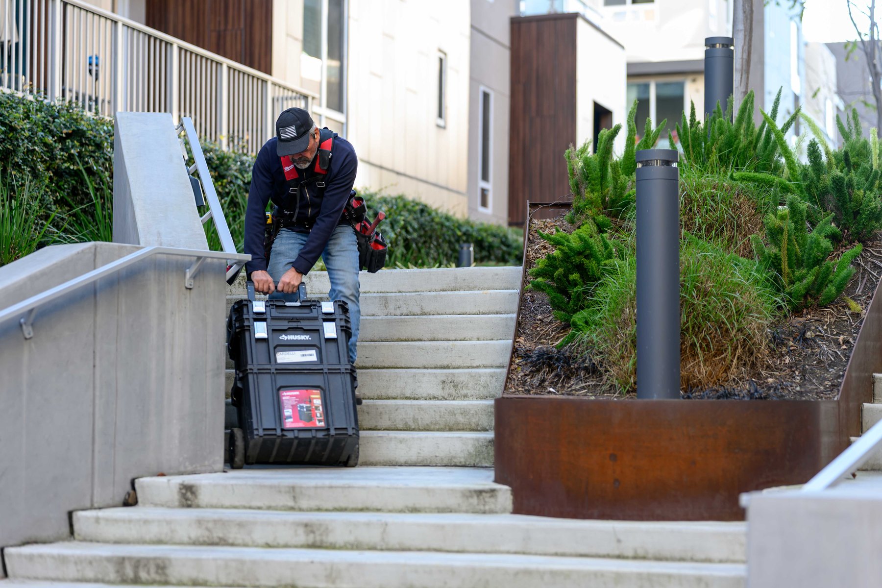 Technician moving tools on stairs during Bay Area field work.