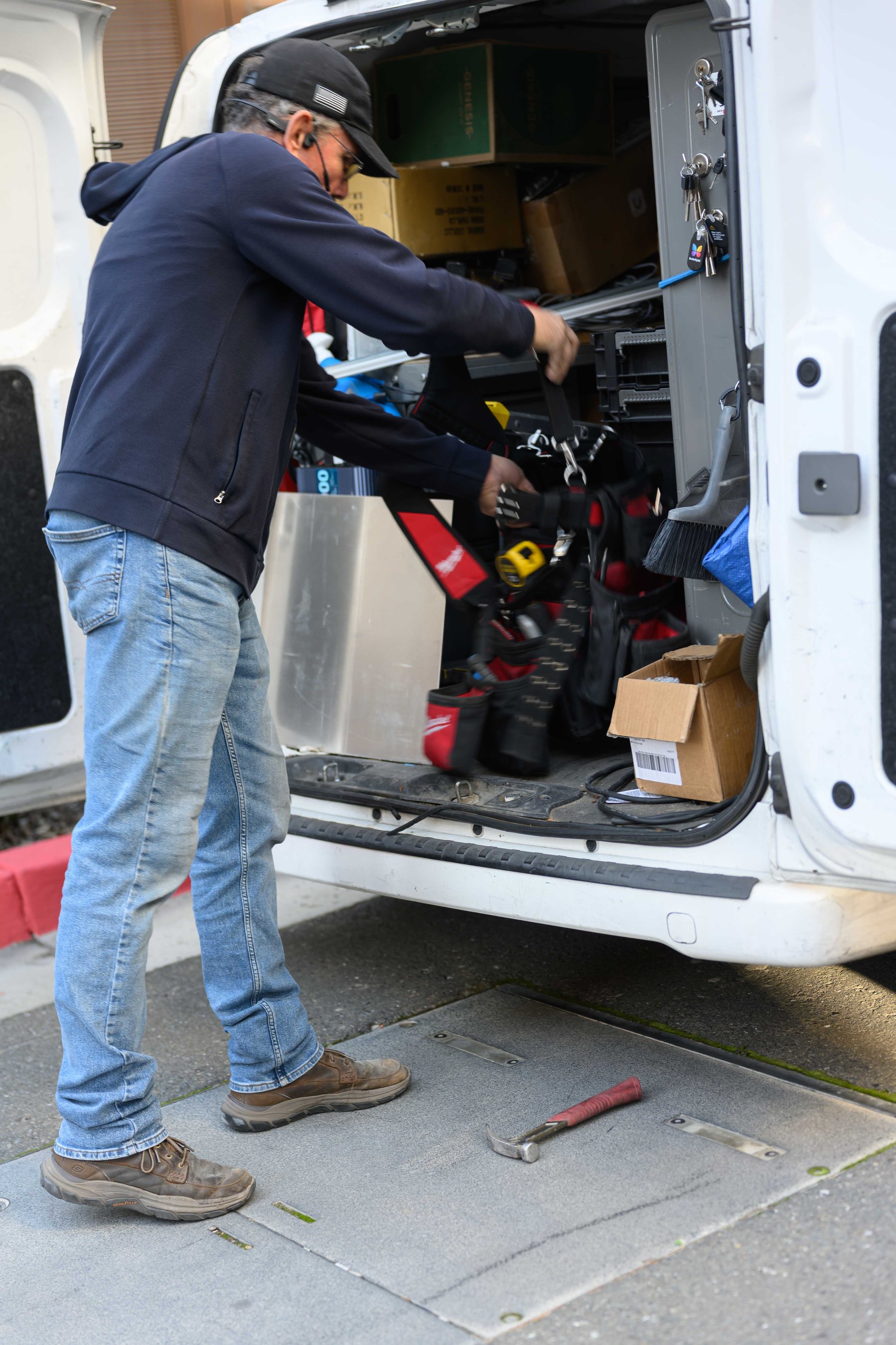 Technician loading tools from a service van for security work.